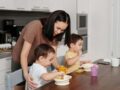 a woman in brown shirt feeding her kids