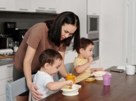 a woman in brown shirt feeding her kids
